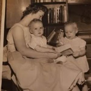 Childhood photograph of Theresa Jehlik, featuring two small children (Jehlik and sibling) being read to by their mother.