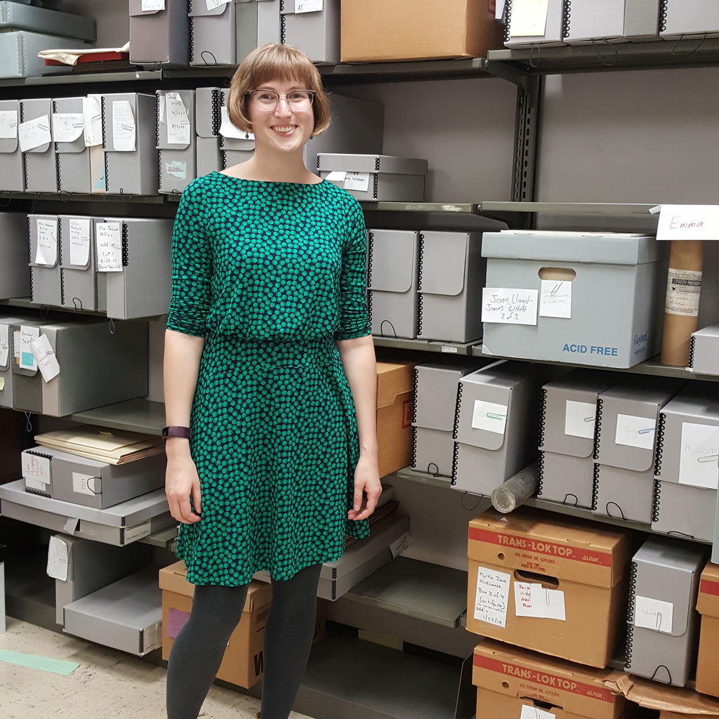 Anna Holland in front of shelves containing archival boxes