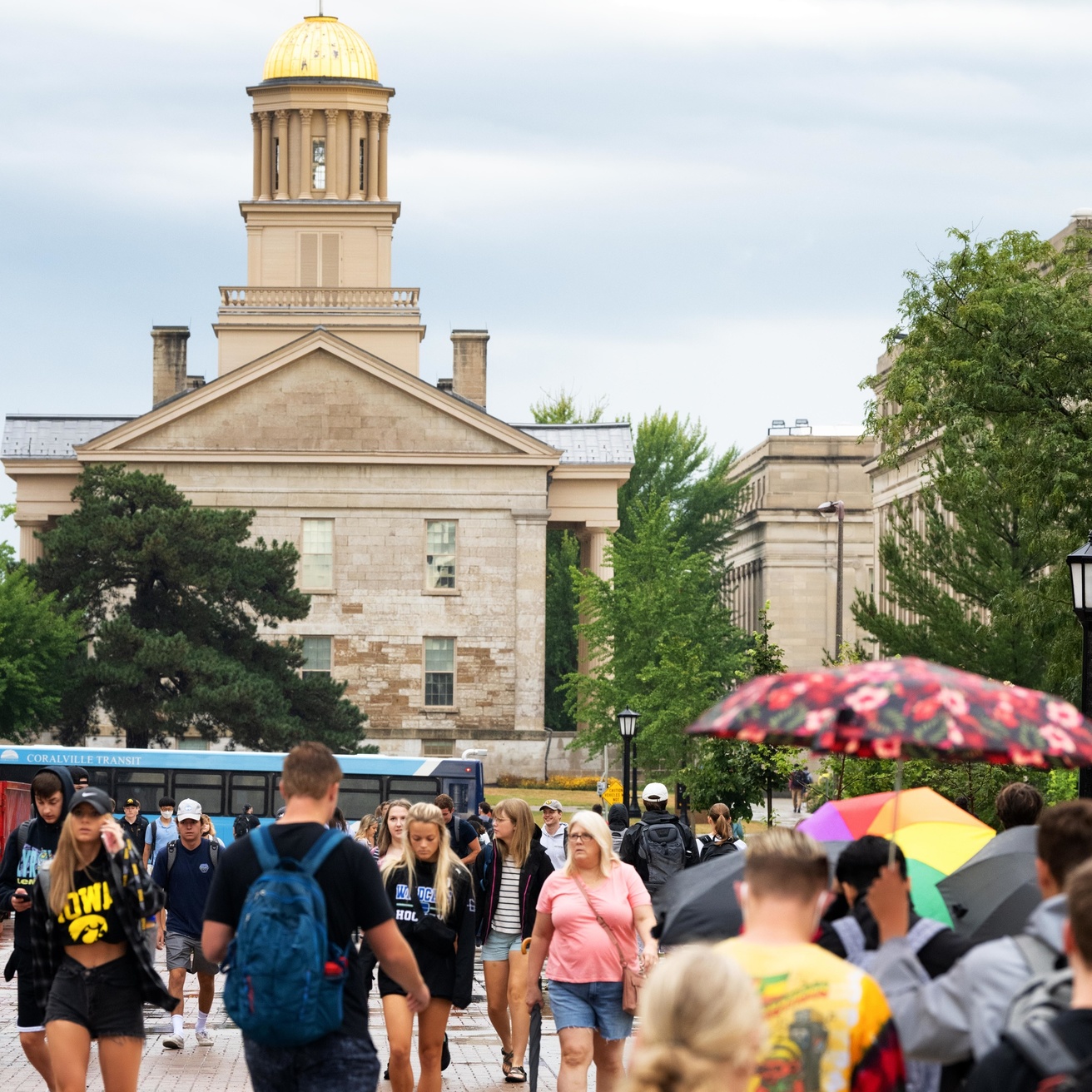 Students walk across the Pentacrest on the first day of classes with the Old Capitol building in the background