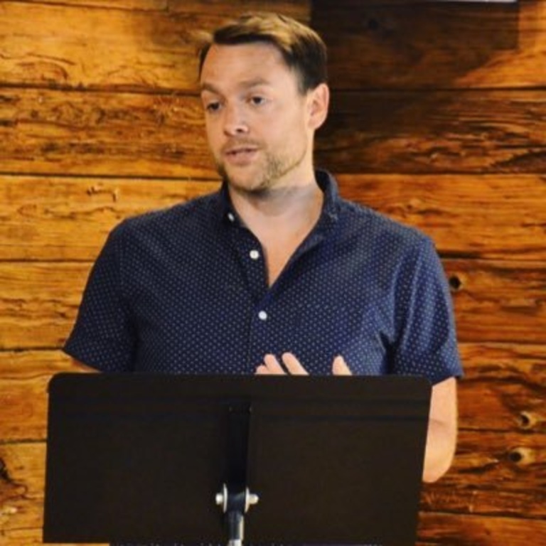 Micah Bateman standing at a podium