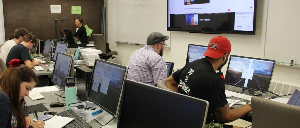 Computer classroom with students sitting at desks